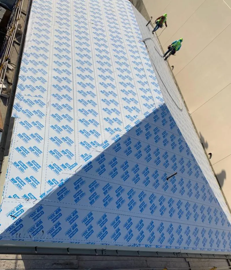 Professional roofers installing underlayment on a metal roof in Totowa